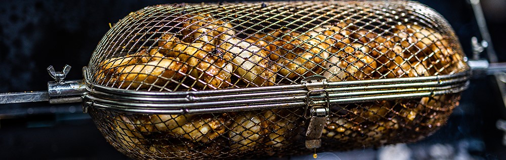 this photo shows chicken drumstick on a spit rotisserie basket